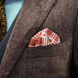 Checkerboard patterned FatCloth Marcus Maroon puff fold in a brown herringbone tweed pocket