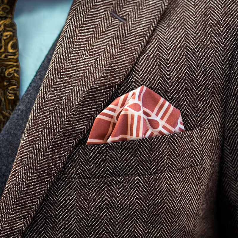 Checkerboard patterned FatCloth Marcus Maroon puff fold in a brown herringbone tweed pocket